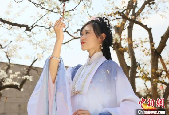 圖為蘭州青年身穿漢服在百年梨園賞景?！「哒?攝