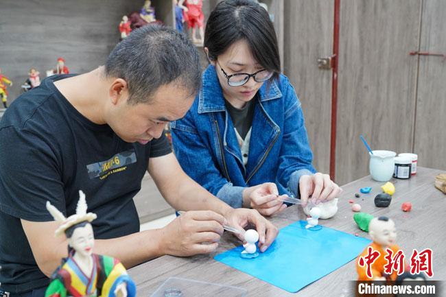 <a target='_blank'  data-cke-saved- >中新社</a>記者(右)現(xiàn)場體驗面塑制作過程?！￡悹帍?攝