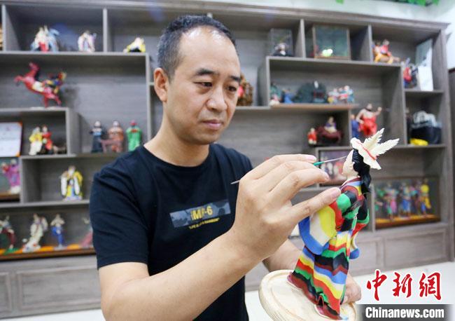 圖為安秋平正在創(chuàng)作代表隴南文縣民俗的《白馬人》作品?！「哒?攝