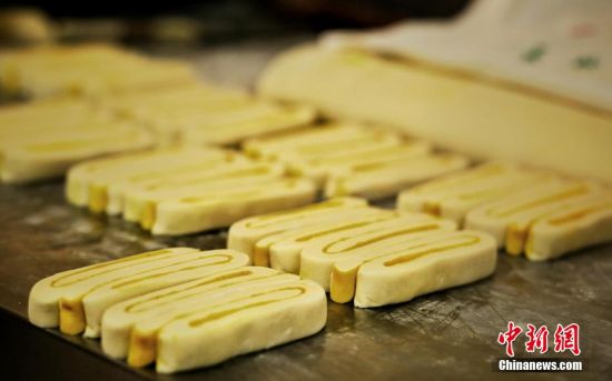 圖為面劑被涂上胡麻油，切成條狀用作月餅的花型制作。張文 攝