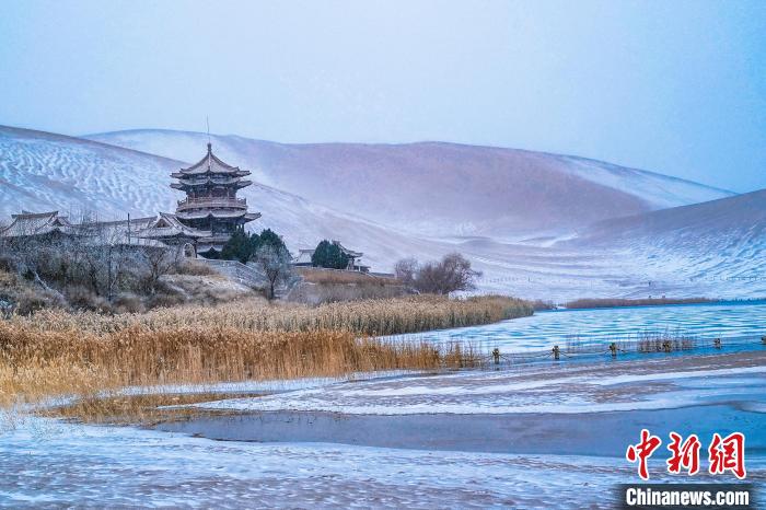 2021年11月28日，雪落鳴沙山月牙泉景區(qū)?！⊥醣筱y 攝