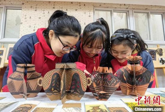 圖為學生用紙創(chuàng)作的立體彩陶?！⒂裉?攝