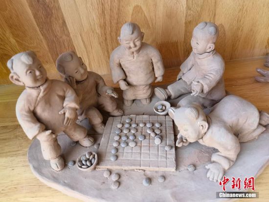圖為泥塑作品展現(xiàn)下棋場景。 劉玉桃 攝