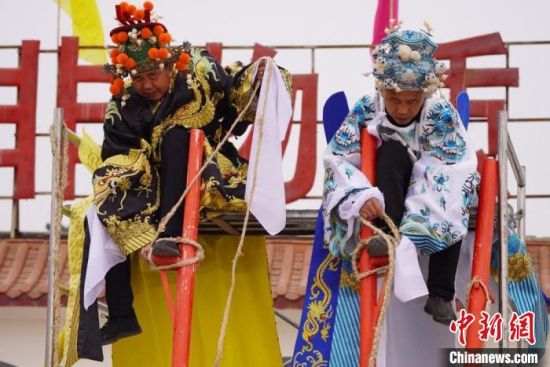 圖為“苦水高高蹺”表演者通過麻繩將腳固定在腳踏板，并在腿部纏繞六七圈?！【琶赖┰?攝