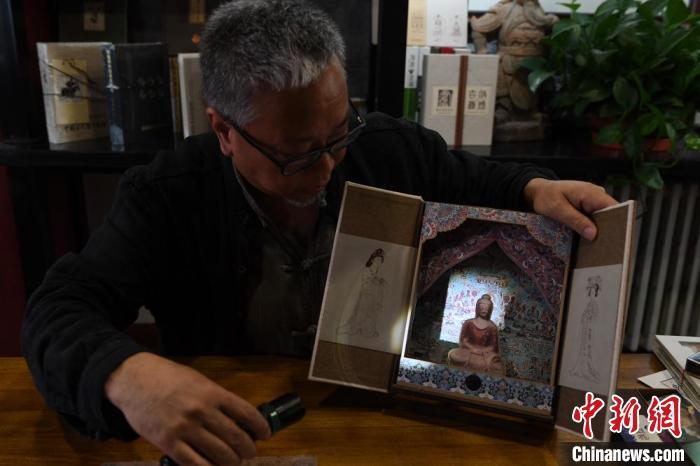 圖為讀者出版集團讀者晉林工作室獨立出品人徐晉林，展示互動性強的敦煌題材手工書。(資料圖) 楊艷敏 攝