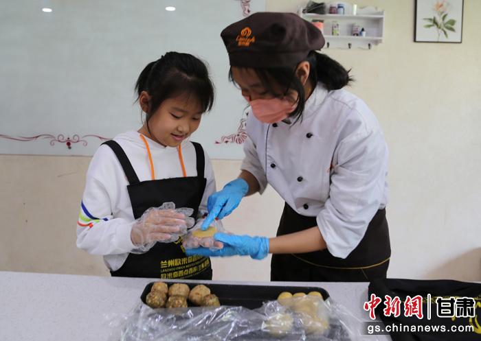 圖為在甘臺(tái)胞小朋友在工作人員指導(dǎo)下制作月餅。九美旦增 攝