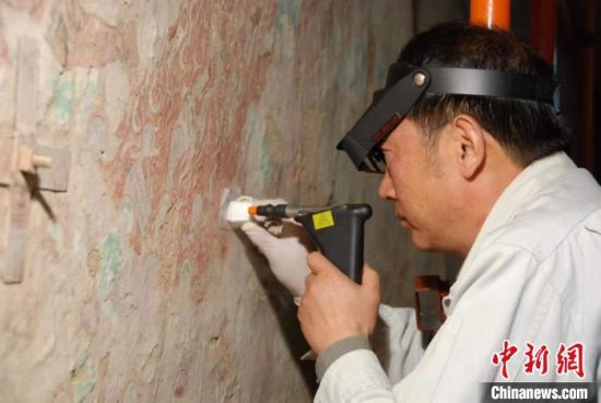 敦煌研究院研究員樊再軒進(jìn)行壁畫修復(fù)。(資料圖)張?jiān)莆?攝