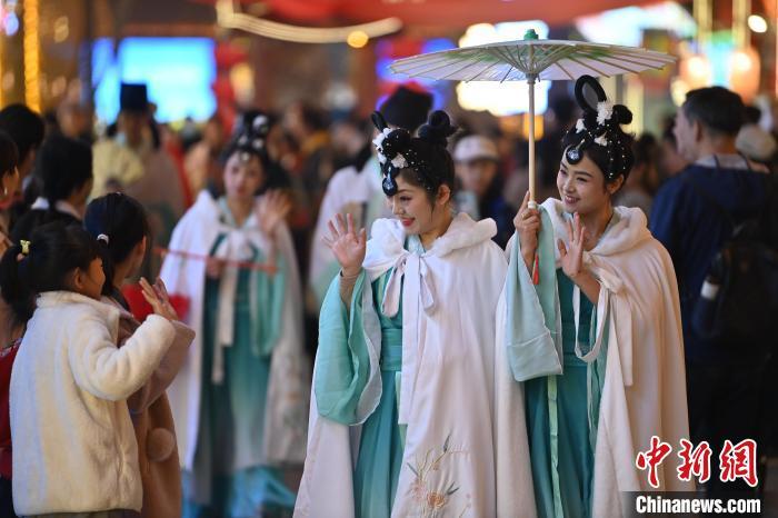 圖為街區(qū)人員著傳統(tǒng)服飾與游人互動。李亞龍 攝</p><p>