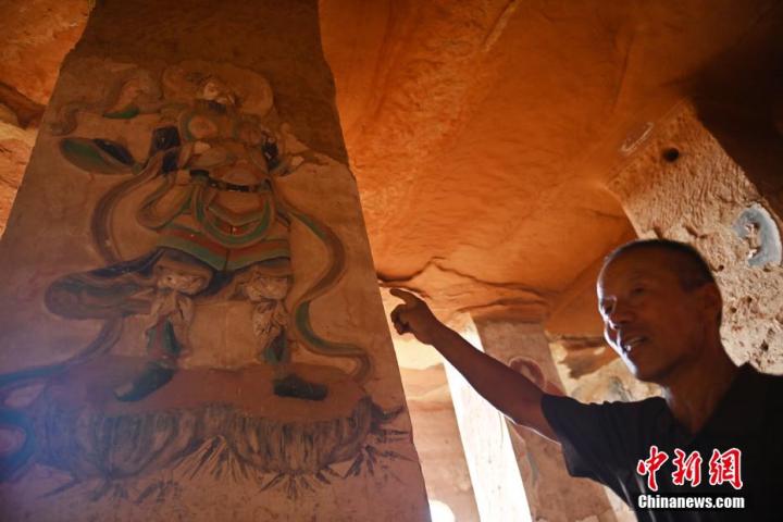 7月15日，甘肅省平?jīng)鍪袥艽h百里石窟長廊羅漢洞石窟內(nèi)，該窟文保員郭建平介紹窟內(nèi)石刻彩繪壁畫。郭建平家中三代人曾自發(fā)保護羅漢洞石窟。羅漢洞石窟遺存40余個窟龕，以北魏至清代風(fēng)格為主。中新社記者 李亞龍 攝</p>
<p>