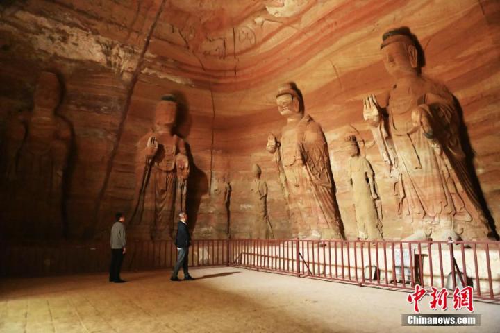 7月15日，游人參觀甘肅省平?jīng)鍪袥艽h百里石窟長廊中的南石窟寺1號窟。百里石窟長廊位于涇川縣境內(nèi)，由512個石窟、5眼窟中石井組成，現(xiàn)存王母宮石窟、鳳凰山石窟、南石窟寺、丈八寺石窟、羅漢洞石窟、太山寺石窟等規(guī)模較大的石窟群，還有數(shù)量眾多的小石窟群。南石窟寺開鑿于北魏永平三年，其中1號窟屬于大型七佛窟，七佛高達6米。中新社記者 李亞龍 攝