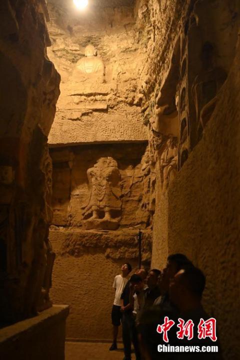 7月15日，游人參觀甘肅省平?jīng)鍪袥艽h百里石窟長廊中的王母宮石窟。百里石窟長廊位于涇川縣境內(nèi)，由512個石窟、5眼窟中石井組成，現(xiàn)存王母宮石窟、鳳凰山石窟、南石窟寺、丈八寺石窟、羅漢洞石窟、太山寺石窟等規(guī)模較大的石窟群，還有數(shù)量眾多的小石窟群。王母宮石窟又名千佛洞，該窟設(shè)計宏大，造像生動，窟內(nèi)擁有造像數(shù)百尊，是較為珍貴的佛教文化遺存。中新社記者 李亞龍 攝</p>
<p>