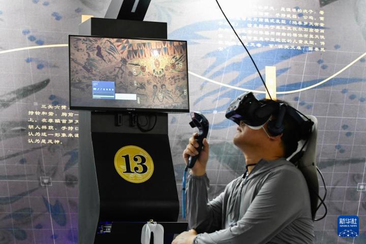 7月22日，游客借助VR設(shè)備沉浸式游覽莫高窟第285窟虛擬場景。新華社記者 郎兵兵 攝